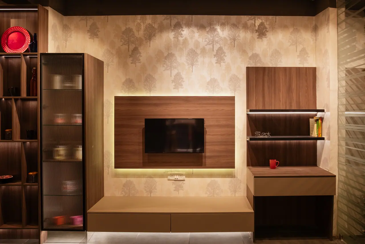 TV unit display with a backlit walnut panel, floating drawer base, fluted glass cabinet and tree-pattern wallpaper