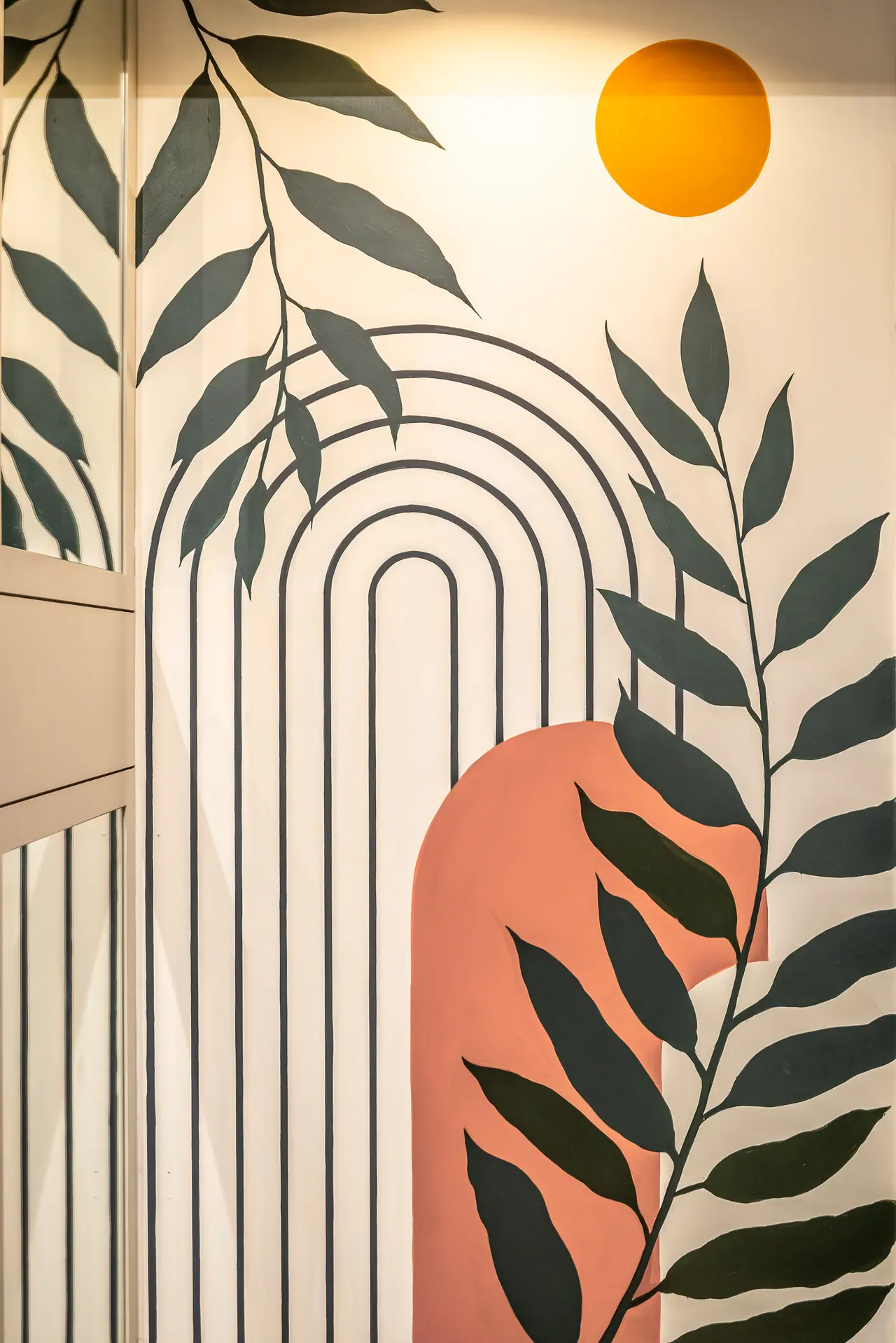 Wall mural of nested dark arches, long dark green leaves, a terracotta arch shape and an orange sun